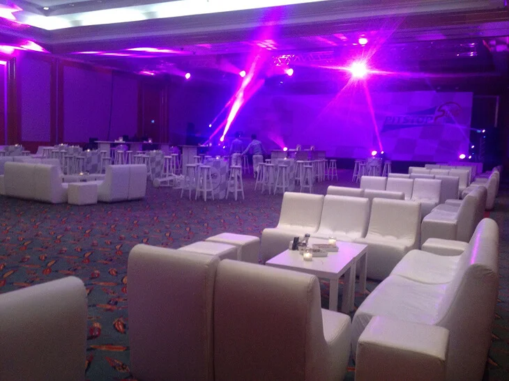 Elegant lounge-style event decoration with white seating, cocktail tables and purple ambient lighting prepared for a corporate evening event in Antalya, Bodrum and Cappadocia