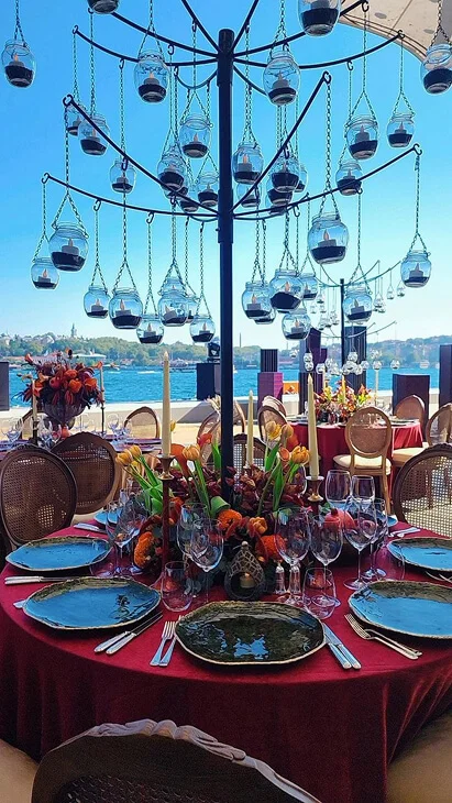 Seaside table design and floral decoration with elegant place settings, hanging candle centerpieces and refined event styling in Antalya, Bodrum and Cappadocia