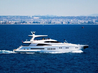 Luxury yacht rental in Fethiye, Turkey featuring a premium motor yacht cruising along the turquoise coastline with panoramic sea views