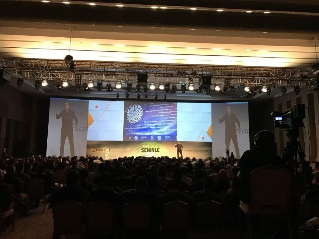 Corporate conference in Antalya, Turkey with a speaker on stage, large presentation screens and seated delegates