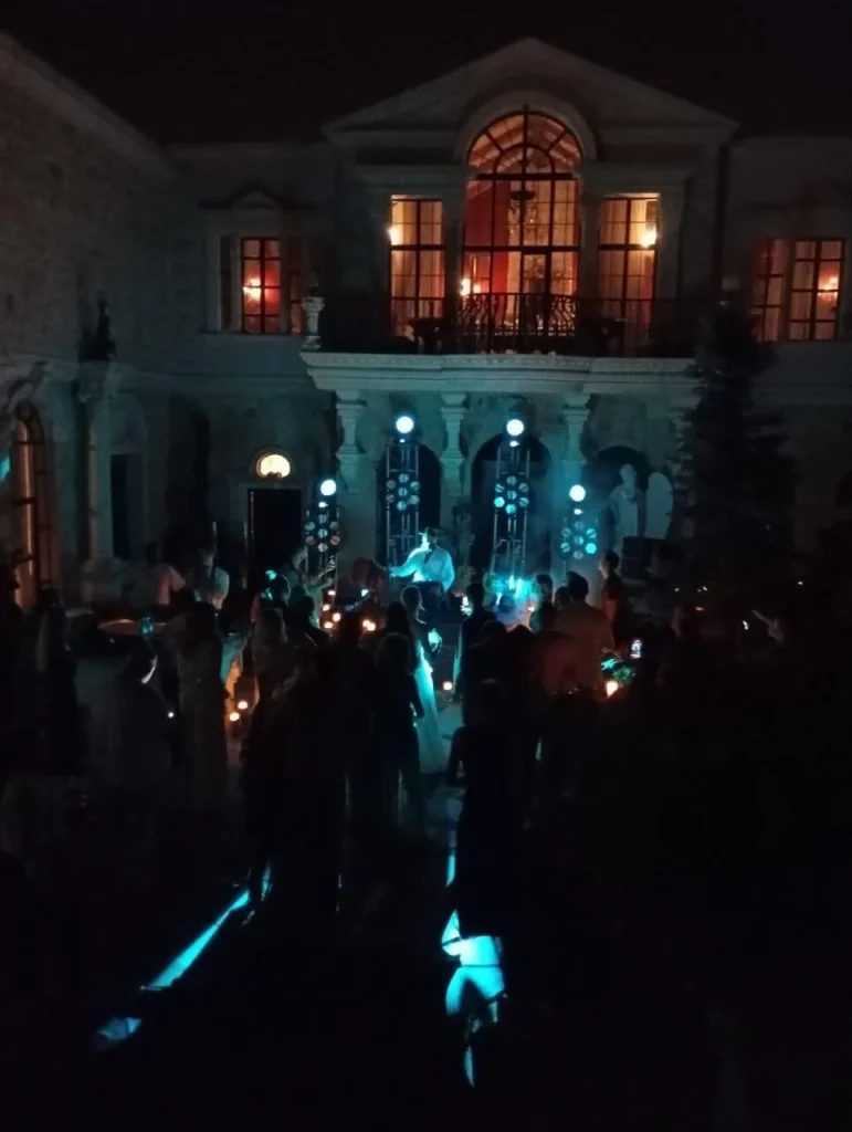 Corporate evening event in Cappadocia, Turkey with guests gathered in a stone courtyard and blue event lighting